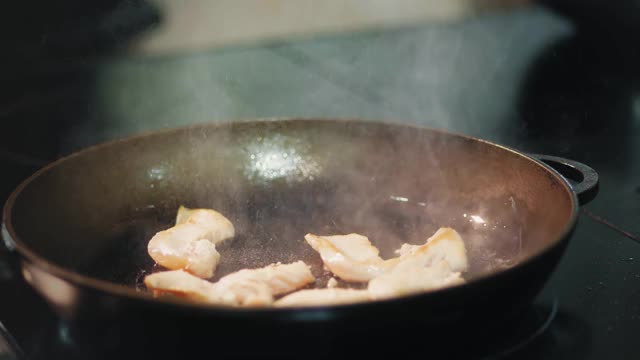 烹饪。特写镜头。肉片在平底锅里煎。烹饪视频素材