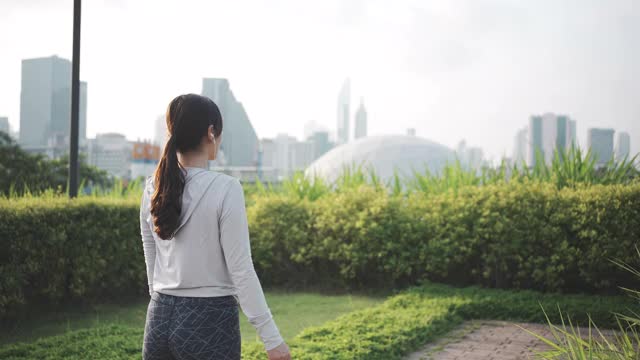 亚洲运动女子热身伸展在城市户外跑步前视频素材