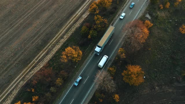 一辆卡车在高速公路上行驶的鸟瞰图，在秋天的日落视频素材