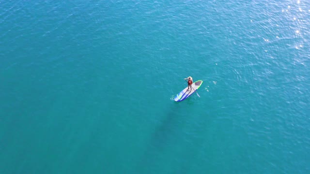 空中俯瞰女人在桨板在海洋视频素材