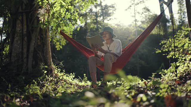 一个年轻人在读一本关于大自然的书视频素材