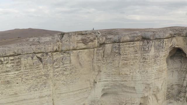 空中全景徒步旅行夫妇漫步在白岩峰周围的山谷景观。活跃的游客男子和女子一起享受徒步探险旅行假期4k视频素材