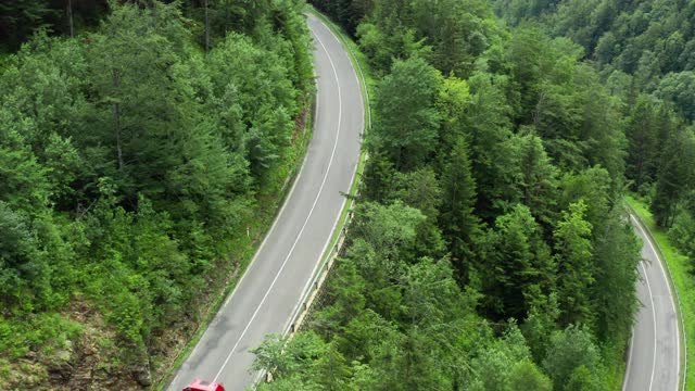 从空中望去，柴油车和汽车在树木环绕的山区道路上行驶。视频素材