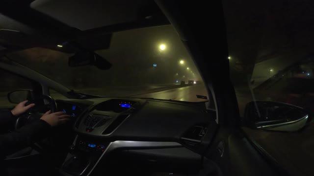 在雨和雾中通过城市的夜间驾驶-视频的4k视频一辆汽车通过城市，用gopro相机从乘客的角度视频素材