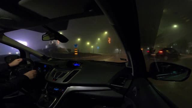 在雨和雾中通过城市的夜间驾驶-视频的4k视频一辆汽车通过城市，用gopro相机从乘客的角度视频素材