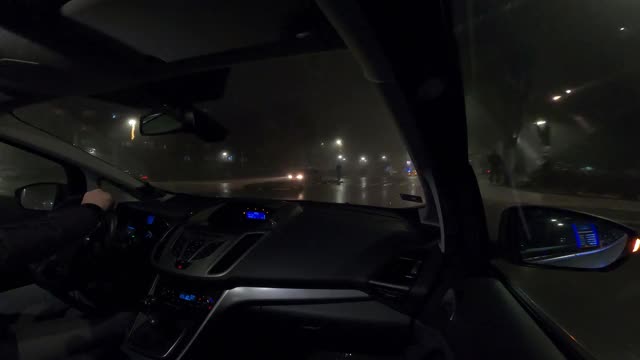 在雨和雾中通过城市的夜间驾驶-视频的4k视频一辆汽车通过城市，用gopro相机从乘客的角度视频素材