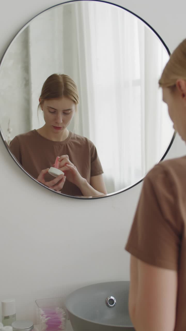 年轻女子在浴室使用面霜视频素材