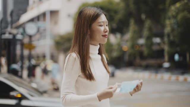 亚洲妇女戴着口罩在街上视频素材