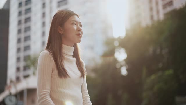 女人戴上耳机，在城市里享受音乐视频素材