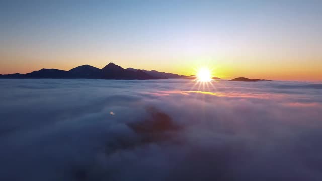 宁静的早晨，在高山低云上飞翔，欣赏美丽的日出全景视频素材