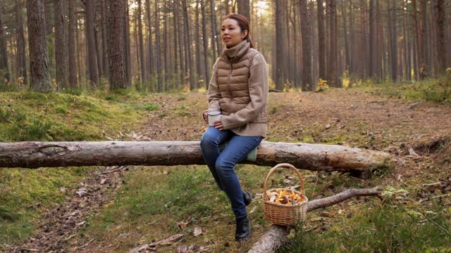 亚洲女人用蘑菇在森林里喝茶视频素材