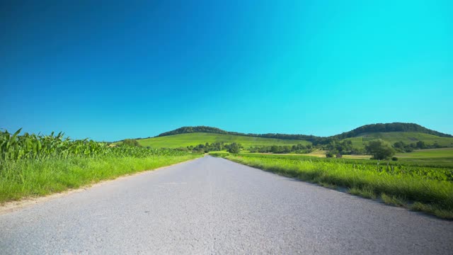 一条穿过草地的狭窄道路，后面是群山视频素材