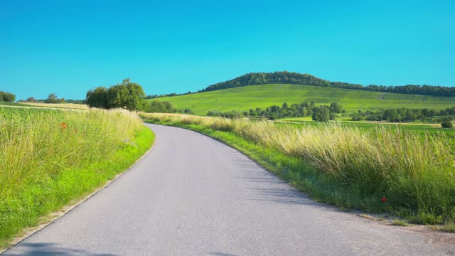 一条穿过草地的狭窄道路，后面是群山视频素材