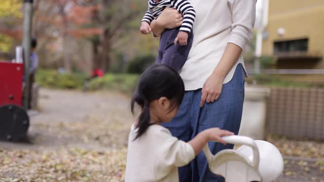 小女孩在公园里玩跷跷板视频素材