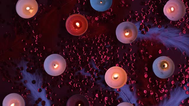 顶视图燃烧的茶灯蜡烛聚集在一起的红色背景。浪漫的氛围与香茗香薰蜡烛。情人节的背景视频素材