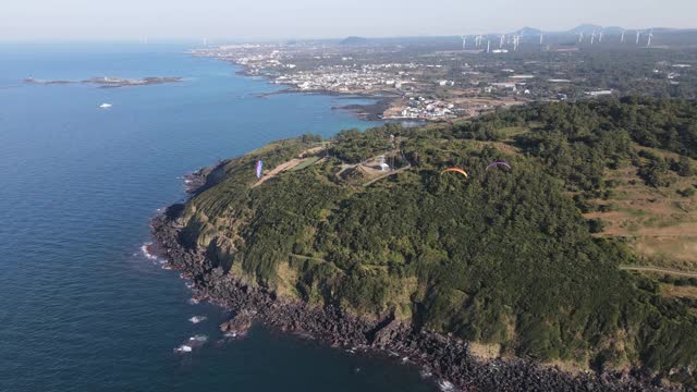 韩国Jeju-do Jeju-si, Jocheon县Hamdeok Seoubong峰滑翔伞视频素材