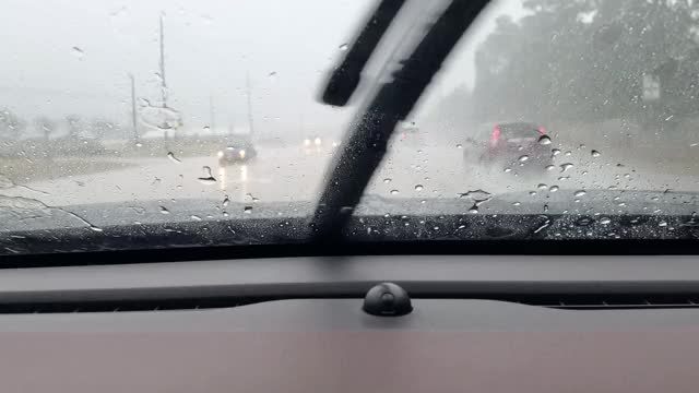 在暴雨中，高速公路司机POV穿过雨滴汽车的挡风玻璃。视频素材