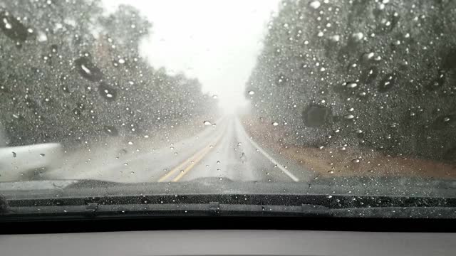 在暴雨中，高速公路司机POV穿过雨滴汽车的挡风玻璃。视频素材