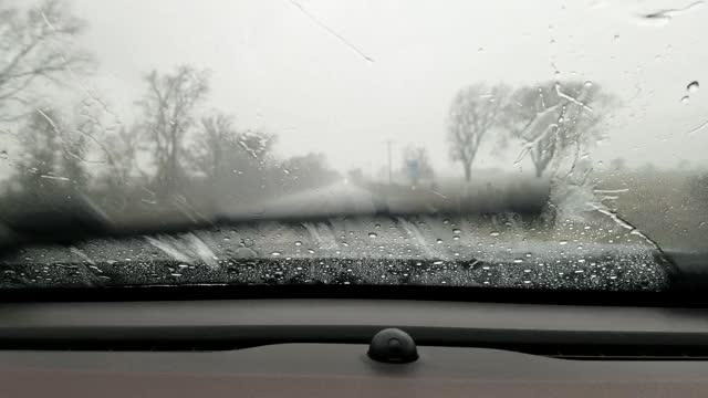 在暴雨中，高速公路司机POV穿过雨滴汽车的挡风玻璃。视频素材