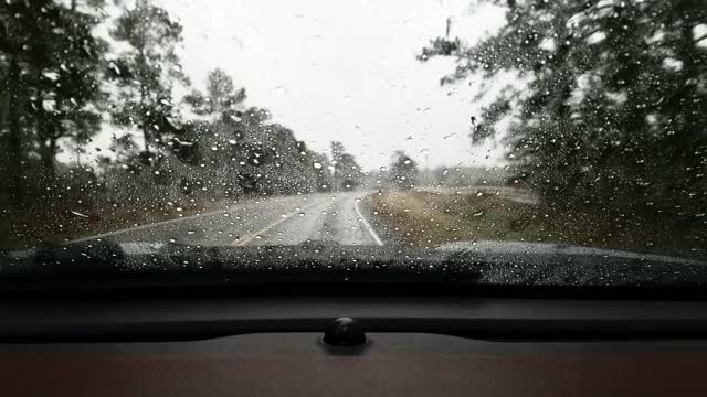 在暴雨中，高速公路司机POV穿过雨滴汽车的挡风玻璃。视频素材