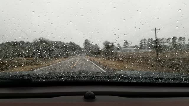 在暴雨中，高速公路司机POV穿过雨滴汽车的挡风玻璃。视频素材