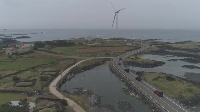 韩国济州岛济州市杭永县新昌风车海岸公路上的汽车行驶视频素材