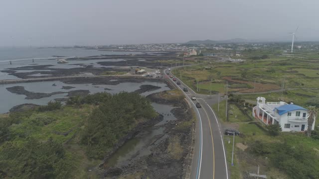 韩国济州岛济州市杭永县新昌风车海岸公路上的汽车行驶视频素材