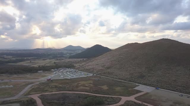 阳光透过云层越过银色的草地和Saebyeol Oreum(寄生火山)在爱越县/济州岛济州岛，济州岛，韩国视频素材