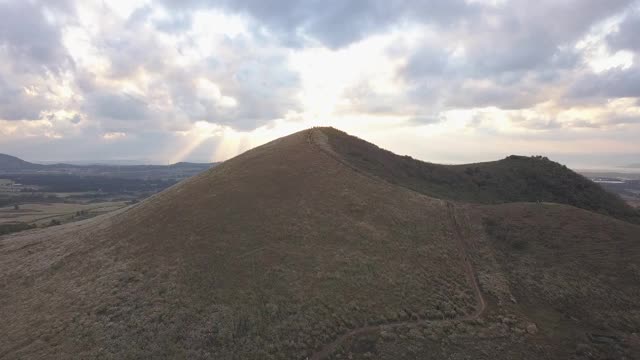 阳光透过云层越过银色的草地和Saebyeol Oreum(寄生火山)，在Aewol县/济州岛，济州岛，济州岛视频素材