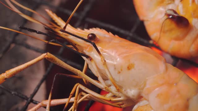 烤虾放在传统的充满火和火焰的火炉上。泰国海鲜菜单和夏季时间。市场,街头食品。美味可口的菜单。微距镜头。视频素材