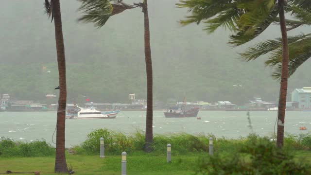 在大雨和暴风下停靠在港口的船只。热带风暴的概念。包含自然声音视频素材