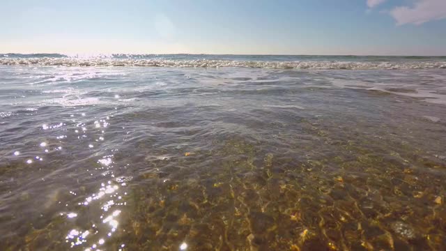 在一个阳光明媚的夏天，温暖的日子里，有海浪的沙滩视频素材