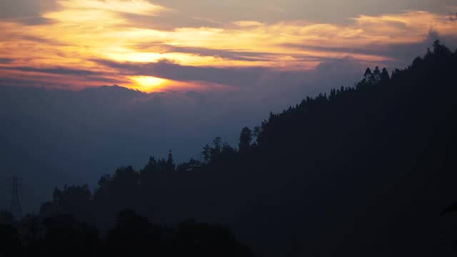 日出在山上与剪影的针叶树。移动云视频下载