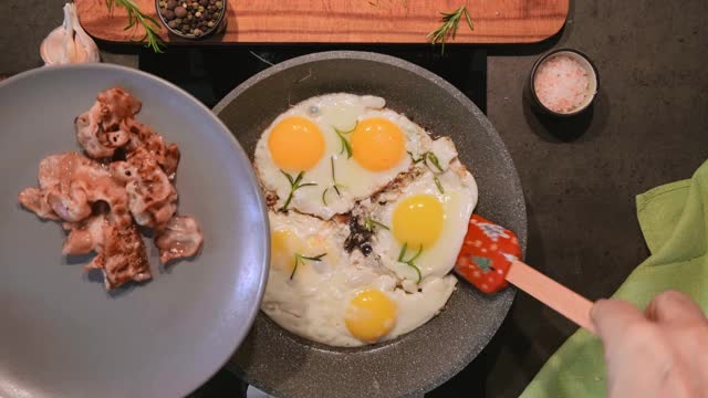 用熏肉、香料和迷迭香煎蛋。俯视图，煎蛋放在盘子上。早餐或生酮饮食的想法视频素材