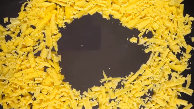 将磨碎的奶酪倒在玻璃表面。底部视图。视频素材