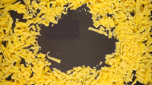 把奶酪揉进一个玻璃碗里。底部视图。磨碎的奶酪。视频素材