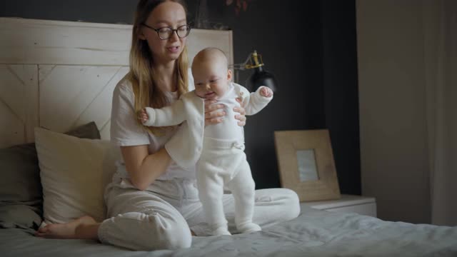 快乐的女人看着她的孩子笑了。漂亮的宝宝朝妈妈笑。母亲和她自己的孩子视频下载