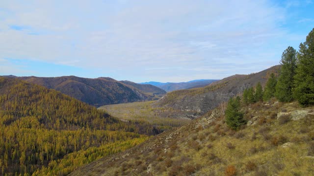 相机从左到右的跨度。多山的地形。秋天的山河在远处视频素材