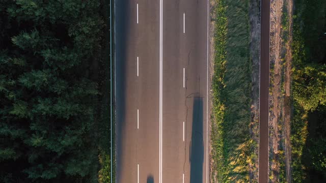 俯视图高速公路与过往的汽车和自行车道在森林。视频素材