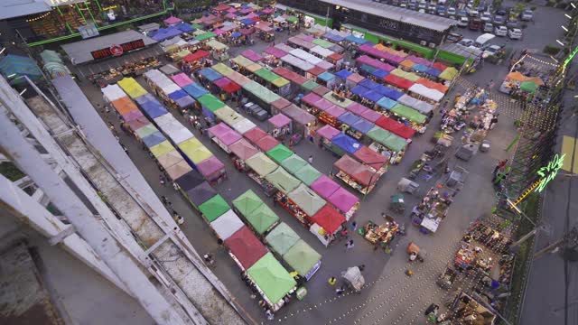 泰国曼谷夜市上的人们走在街上，五颜六色的帐篷在Ratchada的火车上。Rerail商店视频素材