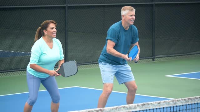 一对玩pickleball，女人打了制胜一球视频素材