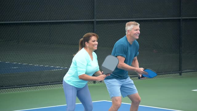 一对玩pickleball，轮流击球视频素材