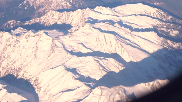 飞机飞越阿尔卑斯山雪山的山峰视频素材