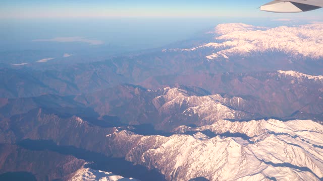 飞机飞越阿尔卑斯山雪山的山峰视频素材