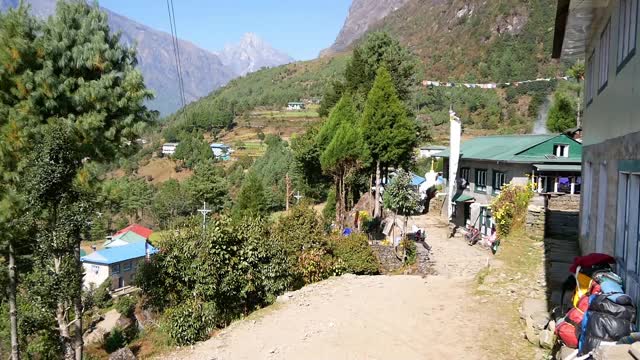 尼泊尔的夏尔巴人村庄靠近Lukla，在喜马拉雅山脉的Dudhkoshi山谷上面，有旅馆建筑和旗帜在阳光明媚的日子在风中飘扬。视频素材