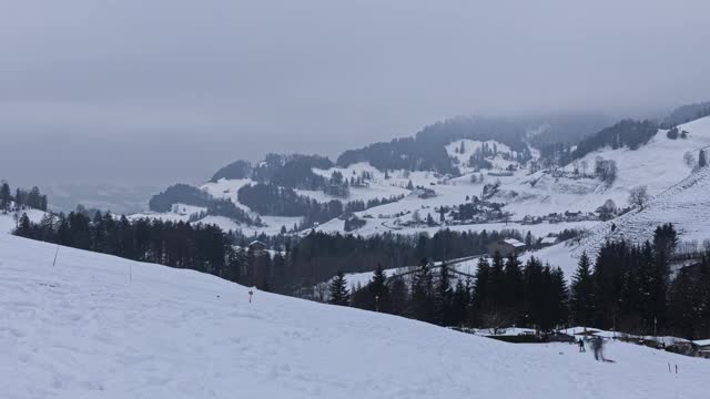 人们在瑞士阿尔卑斯山滑雪橇的时间。山上覆盖着积雪。滑雪胜地Atzmännig，圣加仑州。视频素材