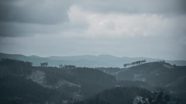 在一个冬天的下午，拜斯基迪山脉的丘陵景观和快速移动的云在小雪下。视频素材