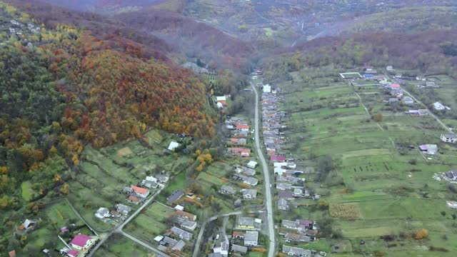 从高处鸟瞰美丽的乡村村庄，有房子和街道在犁地，草地视频素材