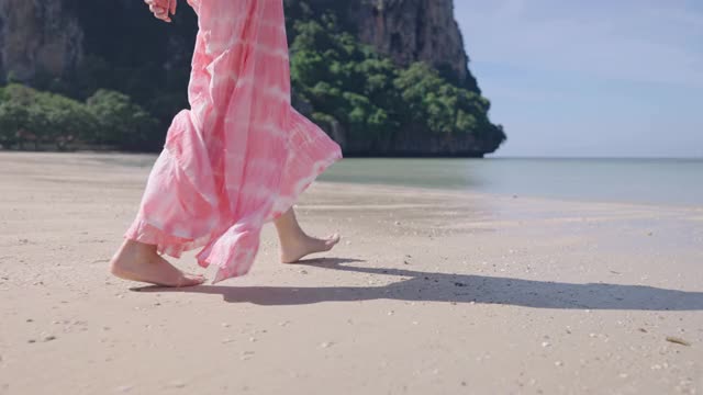 从背后拍摄的年轻女子走在热带岛屿的白色沙滩与清澈的海水，自由旅行的生活方式逃离繁忙的城市，地平线的天空和海洋，理想的旅行视频素材