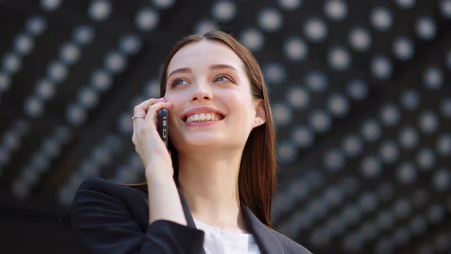 大笑的女人在户外打电话。成功女孩使用手机。视频素材